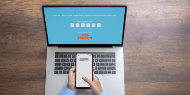 woman’s hand entering a one time password for the validation process