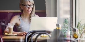 A remote worker working in a coffee shop signifying MDM’s importance